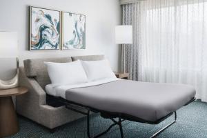 a hotel room with a bed and a couch at Courtyard by Marriott Orlando Downtown in Orlando
