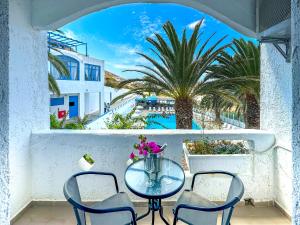 a table and chairs on a balcony with a view of a pool at Bluu Bahari Hotel in Karpathos