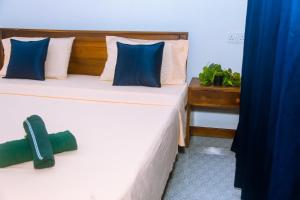 two beds with blue and white pillows in a room at Mirissa Turtle Point Guest in Mirissa