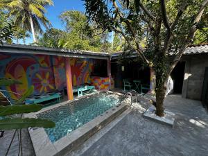 a house with a swimming pool next to a tree at Cycling Backpacker Hostel in Unawatuna