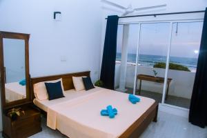 a bedroom with a bed and a view of the ocean at Mirissa Turtle Point Guest in Mirissa