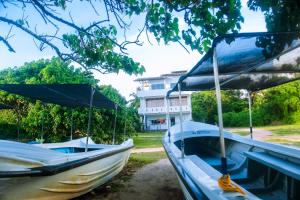 two boats are parked next to a house at Mirissa Turtle Point Guest in Mirissa