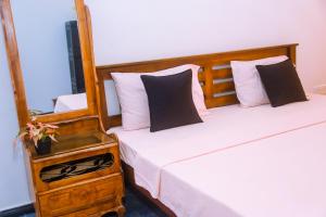 a bedroom with two beds and a night stand with two pillows at Mirissa Turtle Point Guest in Mirissa