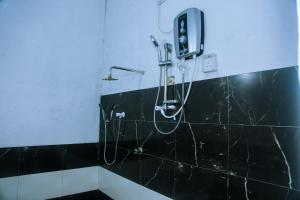 a bathroom with a black tiled wall with a shower at Mirissa Turtle Point Guest in Mirissa