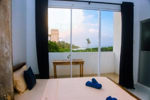 a bedroom with a bed and a large window at Mirissa Turtle Point Guest in Mirissa