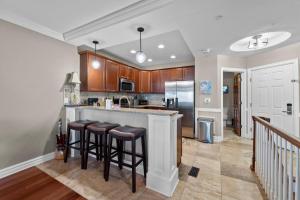 a kitchen with a bar with stools in it at Croatan Surf Club by KEES Vacations in Kill Devil Hills