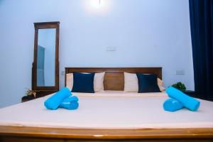 a bedroom with a bed with blue pillows and a mirror at Mirissa Turtle Point Guest in Mirissa