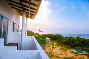 a white building with a view of the ocean at Mirissa Turtle Point Guest in Mirissa