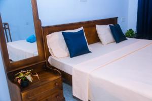 two beds with blue and white pillows in a room at Mirissa Turtle Point Guest in Mirissa