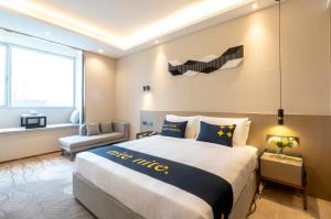 A bed or beds in a room at The Mulian Hotel, Chengdu Frontier Medical Center