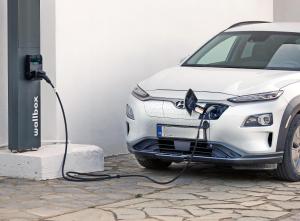 a white electric car plugged into a charging station at Hotel Korali in Troulos