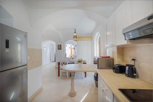 a kitchen with white cabinets and a table in it at Cozy villa with private pool in Upper Nubia in Hurghada