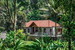 a house with a red roof in a forest at Urava Farmstay- Private waterfall, near Vagamon, Thekaddy, Munnar in Kattappana