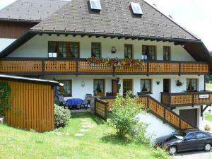 ein großes Haus mit einem Balkon und einem Auto davor in der Unterkunft Gästehaus Klingele in Todtmoos