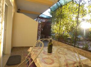 a bottle of wine sitting on a table on a balcony at Beachfront Apartments Plaža in Ivan Dolac
