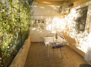 a table and chairs in a room with plants at Beachfront Apartments Plaža in Ivan Dolac +32 photos