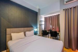 - une chambre avec un grand lit et une table avec des chaises dans l'établissement Cozy Living and Homey Studio Apartment at Margonda Residence 5 By Travelio, à Depok 9 autres photos