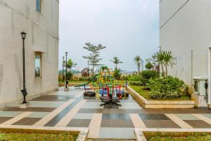 - une aire de jeux avec toboggan dans la cour dans l'établissement Cozy Living and Homey Studio Apartment at Margonda Residence 5 By Travelio, à Depok