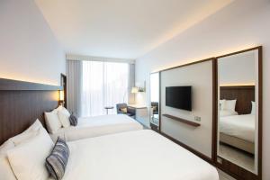 爱丁堡Courtyard by Marriott Edinburgh West的有两张床和一台电视的酒店房间