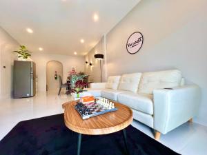 un soggiorno con un divano bianco e un tavolo di Vacanza Home Betong วาคานซ่า โฮม เบตง a Ban Komo Sip Paet
