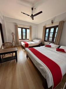 una camera da letto con due letti e un ventilatore a soffitto di Hotel Bhagya a Pokhara