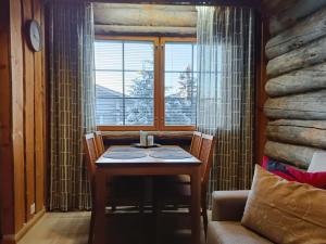 Una mesa y sillas en una habitación con ventana. en Huipuntupa B7, en Syöte