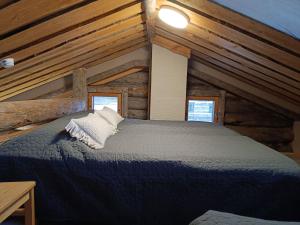 Un dormitorio con una cama en una cabaña de troncos en Huipuntupa B7, en Syöte
