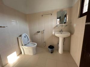 un bagno bianco con un water e un lavandino di Hotel Bhagya a Pokhara