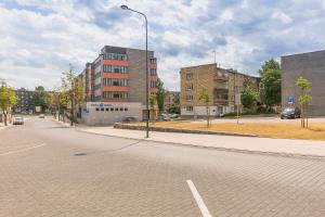 an empty city street with buildings and a street light at Town Square Apartment in Panevėžys