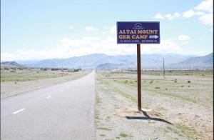 a sign on the side of a road in the desert at Altai Mount Camp in Ölgiy