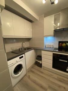 a kitchen with a washing machine and a sink at 2-Bed Sleeps 4 Comfy For Contractors With Free Parking in Crawley near Gatwick Manor Royal Refurbished in Crawley