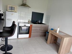 a kitchen with a stove and a tv in it at Petite maison sur aérodrome in Cosne-Cours-sur-Loire