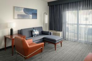 a living room with a couch and a chair at Courtyard Melbourne West in Melbourne