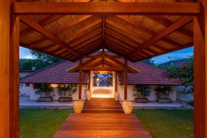 a wooden walkway leading to a house with a roof at Villa Kimaya Bali in Badung