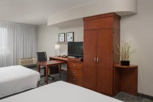 a hotel room with a desk with a television and a cabinet at Courtyard by Marriott Miami West/FL Turnpike in Miami +18 photos