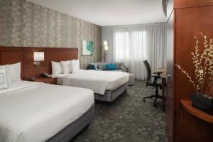 a hotel room with two beds and a desk at Courtyard by Marriott Miami West/FL Turnpike in Miami