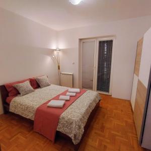 a bedroom with a large bed with red pillows at KNEZ apartman in Požarevac