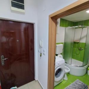 a bathroom with a toilet and a washing machine at KNEZ apartman in Požarevac +7 photos