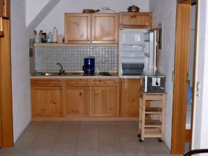 cocina con armarios de madera y nevera en Gästehaus Klingele, en Todtmoos