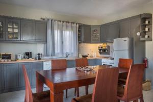 a kitchen with a table and chairs and a white refrigerator at Zādos Central Garden Villa, Lixouri Nomāde in Lixouri