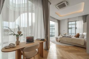 a bedroom with a bed and a desk with a table at Nature's Rest Private Pool Villa Rawai in Rawai Beach +21 photos