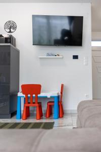 een woonkamer met een tafel en een rode stoel bij Dream Apartman Aliga II in Balatonvilágos