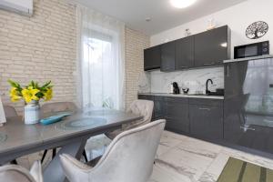 een keuken met een tafel en stoelen in een kamer bij Dream Apartman Aliga II in Balatonvilágos