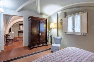 a bedroom with a bed and a cabinet and a chair at Residenza Gatteschi in Pistoia