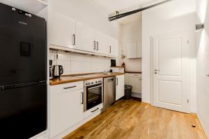 a kitchen with white cabinets and a black refrigerator at 125qm Loft nahe Stadt und Hafen in Hamburg +5 photos