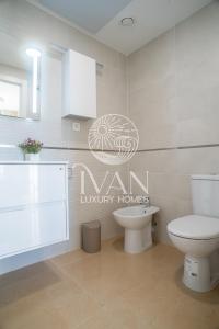ein Bad mit WC und ein Schild an der Wand in der Unterkunft Casa Esona Ivan Luxury Homes 9ªPlta Norte 1ªLinea in Oropesa del Mar