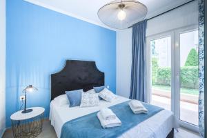 a blue bedroom with a large bed and a window at Icon Deluxe accommodation in Pefkochori