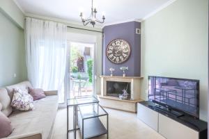 a living room with a couch and a clock on the wall at Icon Deluxe accommodation in Pefkochori +14 photos