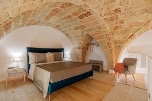 a bedroom with a bed and a brick wall at ARFE' Typical Guesthouse in Casarano