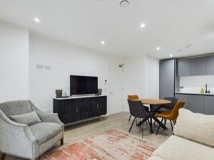 un salon avec un canapé, une table et des chaises dans l'établissement Stunning modern 1 bed apartment, à Belfast